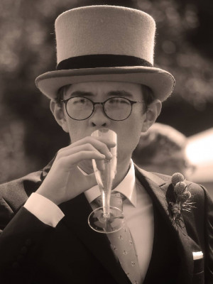 An image of a man in a top hat drinking champagne.