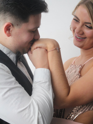 A well shot photo of a man kissing a woman's hand.