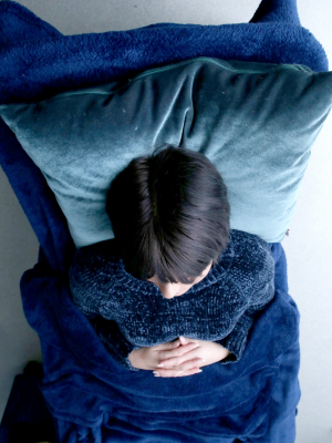an image of a woman lying down and holding her stomach