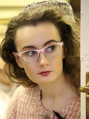 A well shot photo of a woman with glasses.
