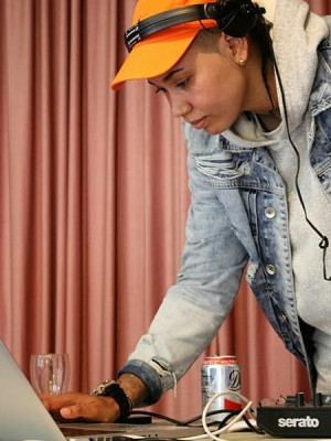 A well shot photo of a woman being a DJ.