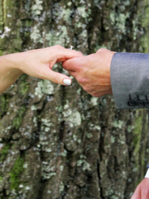 A well shot photo of a groom and a bride with the wedding ring as the main focus.