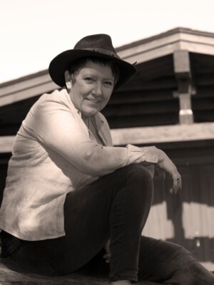 A well shot photo of a woman sitting on a log.
