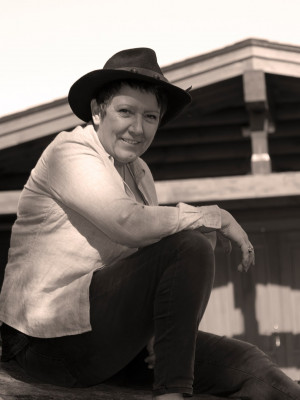 A well shot photo of a woman sitting on a log.
