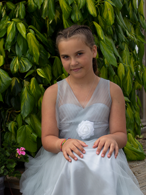 An image of a little girl wearing a dress and sitting down.
